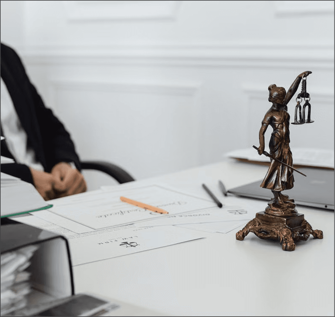 Notary signing documents beside a Lady Justice statue